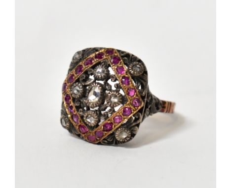 A George III yellow and white metal ruby and diamond ring, with pierced scroll decorated platform and carved detail to the ba