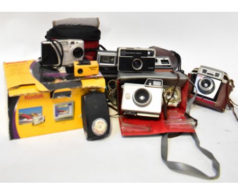 A collection of cameras to include a Polaroid 600 Land Camera, a Kodak EK 100 instant camera, a Minulta AF-E II, etc.