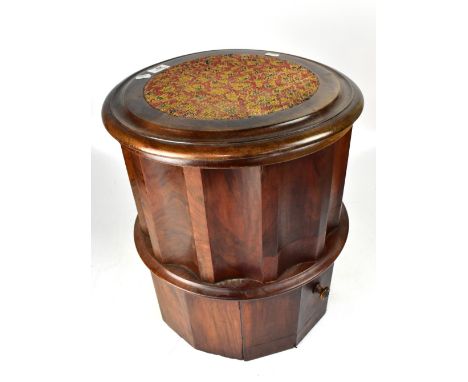 An Edwardian mahogany circular commode with tapestry lift-off top revealing a while ceramic bowl and cover, with pull-out tap