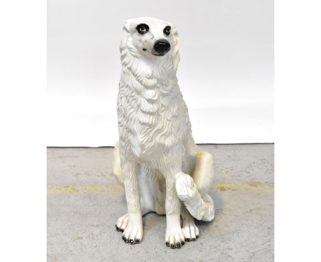 A large near life sized ceramic figure of a seated Afghan hound, white with black detail to face and paws, height 76cm.