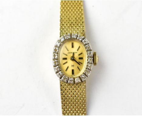 HAMILTON; a ladies' 1970s 14ct gold and diamond wristwatch, the oval dial set with raised baton numerals, crown wind movement