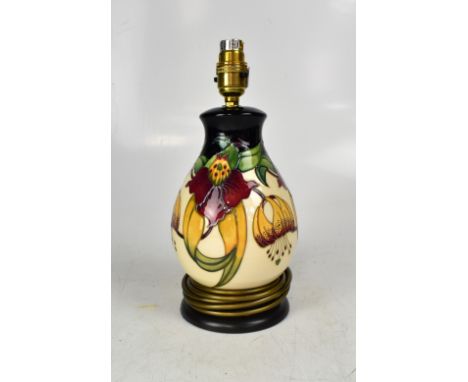 MOORCROFT; a modern baluster-form table lamp decorated in the 'Anna Lily' pattern, on a turned wooden base, height to the top
