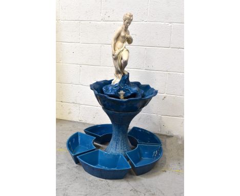 An interior water feature modelled as a semi-nude figure on rocks in flower head shaped dish, on bamboo-effect waisted column