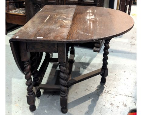 An oak late 19th century early 20th century barley twist drop leaf dining table and an oak early 20th century buffet sideboar