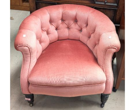 A Victorian button back tub armchair in pink Dralon, on turned legs.
