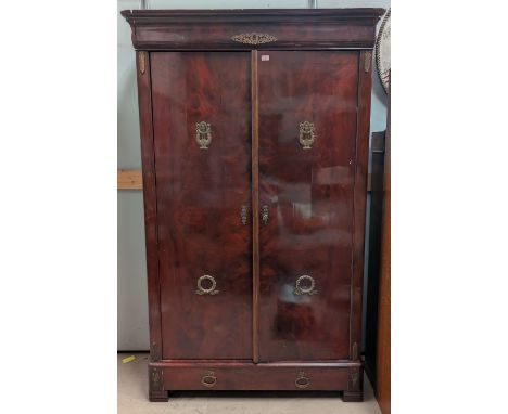 A 19th century French Empire-style mahogany wardrobe with brass lyre and wreath decoration, double doors and a drawer below, 