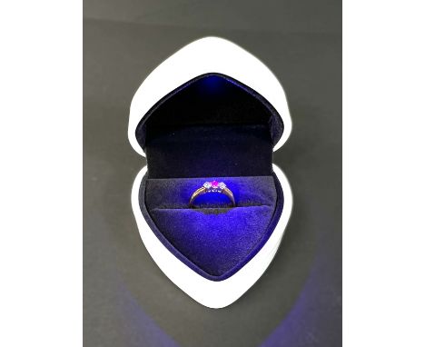 An 18ct hallmarked gold 3-stone ring set with a central ruby flanked by 2 diamonds, central stone diameter 2.5mm, size 'M', 3