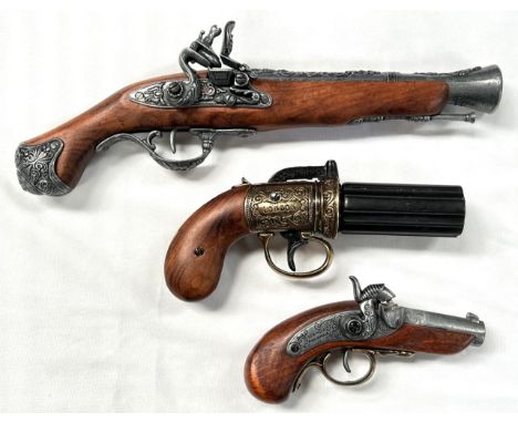 A reproduction display model of an antique rotating barrel pistol and two similar flintlock display pistols