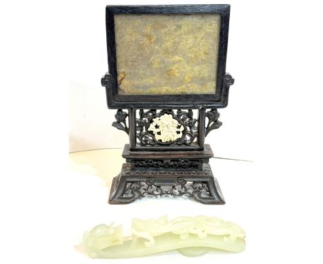 A Chinese jade carved panel inset in pierced and carved wooden stand, ht. 15cm; a pale celadon jade belt hook.In good conditi
