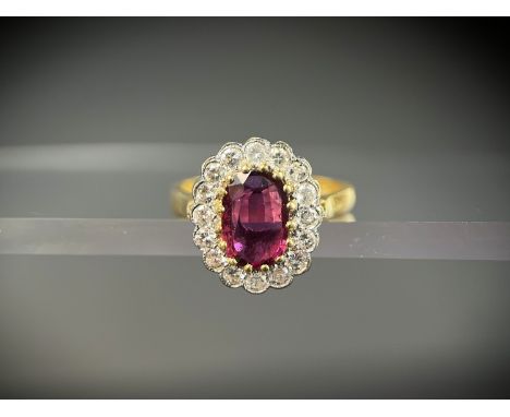 A lady's 18ct hallmarked gold dress ring set with central oval ruby approx. 10 x 7mm surrounded by 16 diamonds, size N, 5.4gm