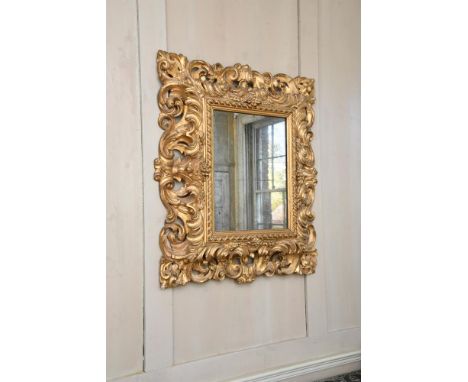 AN ITALIAN CARVED GILTWOOD WALL MIRROR POSSIBLY FLORENTINE, FIRST HALF 18TH CENTURY 85cm high, 73cm wide overallProvenance: P