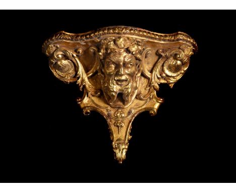 A LARGE GEORGE II CARVED GILTWOOD BACCHUS HEAD WALL BRACKET CIRCA 1765 Central mask flanked by foliate scrolls 57cm wide, 46c