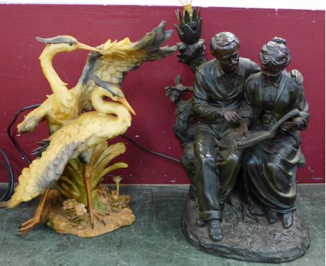 A figural table lamp and a resin model of two herons