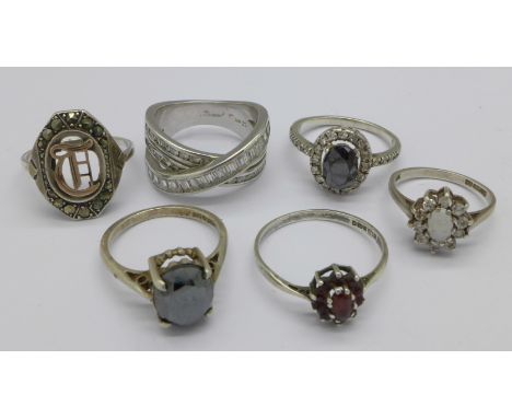 Six silver rings, one set with opal