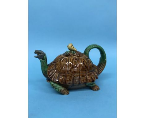 A rare Minton majolica tortoise teapot, the tortoise's head protruding from its brown shell to form the spout, its tail exten