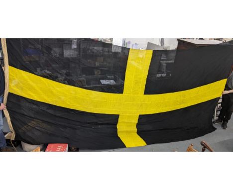 A very large vintage Welsh St David's flag with a yellow cross on a black background, 210cm x 450cmLocation: 