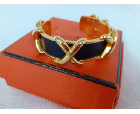 Hermes-A vintage gold tone criss cross cuff bracelet having 4 'X''s with inset smooth black leather band, together with an or