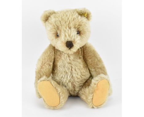 A 1950s Steiff teddy bear, in light mohair, with small hump, straw-filled, with brown stitched nose and paws, felt pads, join