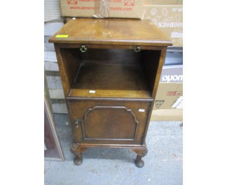 An early 20th century walnut pot cupboard, the top with brushing slide over an open shelf, cupboard door below, on short cabr