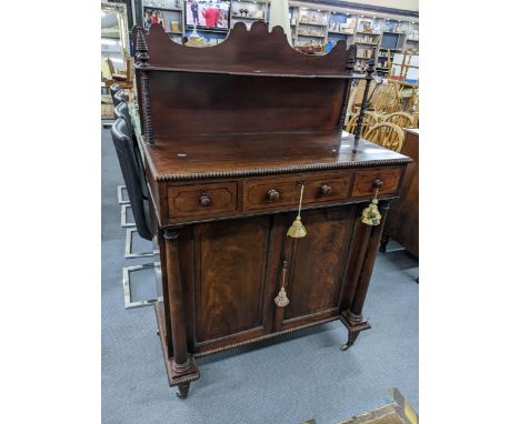 A Regency secretaire/chiffoniere with raised back, gadroon decorated shelf, flanked by ring turned columns, one central secre