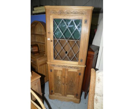 Light oak corner cupboard with lead glazed doors above two cupboard doors