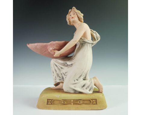 Hand-painted Royal Dux porcelain figurine depicting a neoclassical-style woman in a flowing gown, kneeling while holding a la