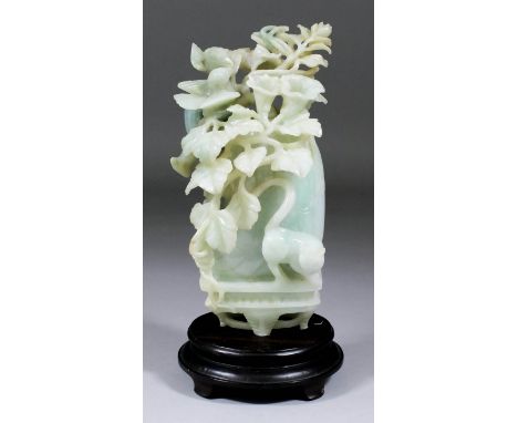 A Chinese pale green and white celadon jade carving in the form of a vase of flowers with two birds perched on a branch and w