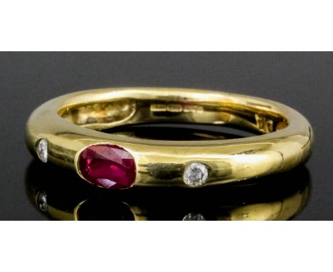 A modern 9ct gold ruby and diamond set ring, set with an oval cut ruby approximately .10ct bordered by two small rose cut dia