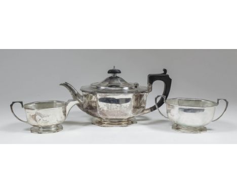 A George V silver three piece tea service of octagonal panelled form with angular handles and on octagonal bases, comprising 