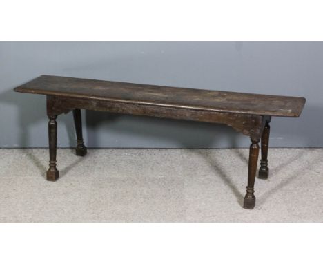 An old oak rectangular bench of "17th Century" design, on turned and angled legs, 59ins wide x 12.5ins deep x 20ins high (top