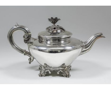 An early Victorian silver circular teapot with floral and leaf cast finial, reeded scroll handle and spout, on leaf and scrol