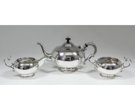 A 20th Century Indian silvery metal three piece tea service with shaped footrims, the teapot with cast silver handle and engr