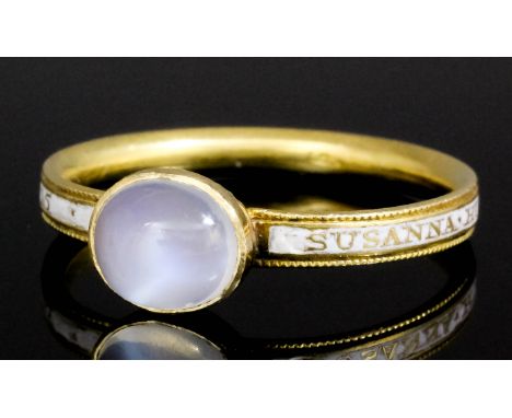 A mid 18th Century gold coloured metal mounted white enamel and moonstone set mourning ring, the central collet set cabochon 