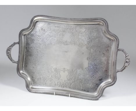 A late Victorian silver two-handled tray of shaped outline with gadroon mounts, gadroon and shell cast handles, the centre en