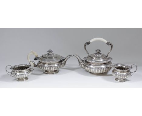 An Edward VII silver Harlequin four piece tea service with shaped, scroll and gadroon cast mounts, part reeded and stop flute