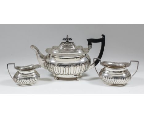 A George IV silver teapot of Georgian design, with partly fluted body on four ball feet by Walker & Hall, 6.5ins high, Sheffi