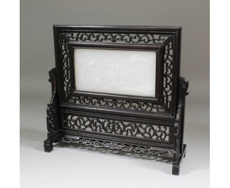 A Chinese hardwood framed rectangular table screen inset with white soapstone plaque, carved with exotic birds and flowers, 1