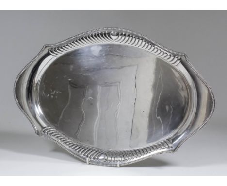 An Indian silvery metal oval tray, the shaped rim with bead mounts and partly reeded, 18ins x 12ins (weight 32ozs)