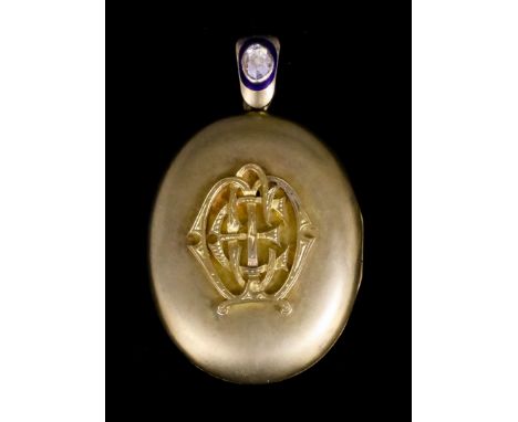 A late Victorian gold coloured metal locket with applied pierced and engraved initials to the face for "C.E.M.", 60mm x 38mm 