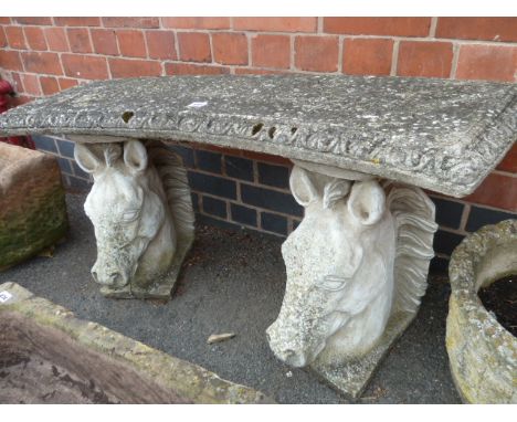 Curved stone bench on horses head supports