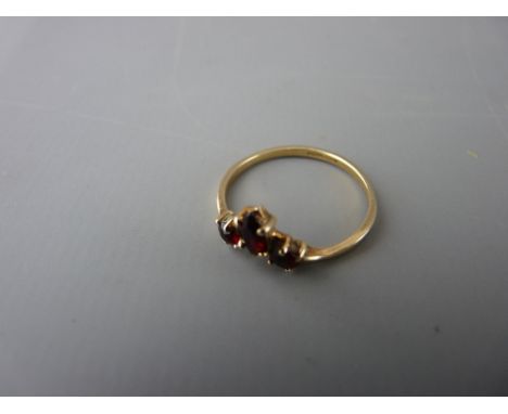 Small nine carat gold ring set with three small garnet type stones