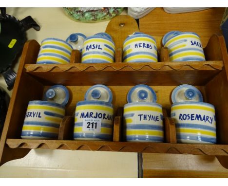 Wooden spice rack with eight pottery spice containers and lids