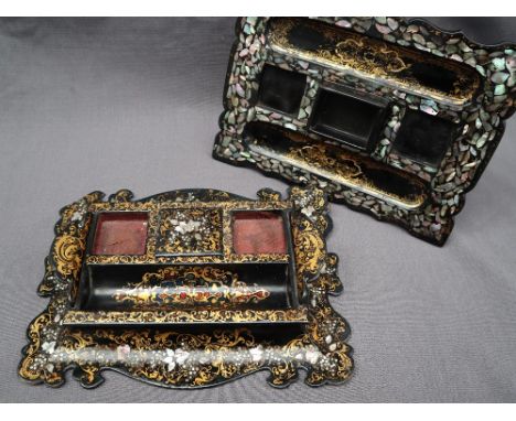 A papier mache desk standish, of scrolling form, decorated with mother of pearl and scrolling gilt leaves, 30cm wide together
