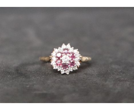 A 9ct gold ruby and diamond cluster ring, set with a central round brilliant cut diamond, a tier of six rubies and a tier of 