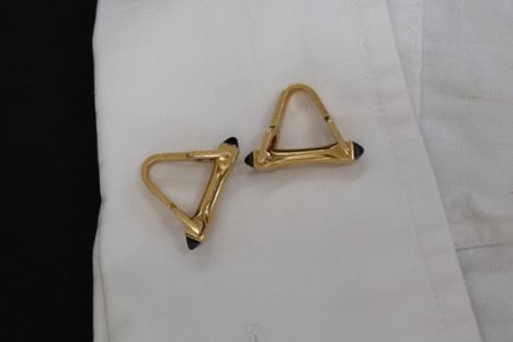 A pair of Boucheron of Paris yellow metal cufflinks of stirrup form with sugarloaf sapphire terminals, script mark and marked