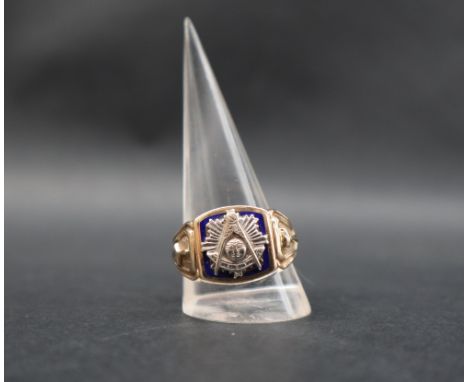 A Masonic ring, with raised white metal square, compass and  radiating sun to a blue enamel ground, mounted in yellow metal, 