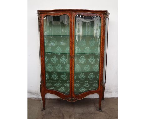 A French kingwood and ormolu mounted vitrine, with a serpentine top above a pair of glazed doors and sides on shaped legs and