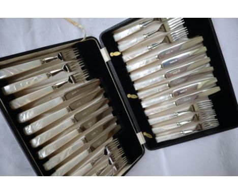 A set of twelve George V silver fruit knives and forks, with silver blades and tines to mother of pearl handles, cased, Viner