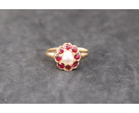 A ruby and pearl dress ring, with a central pearl and eight faceted rubies to a yellow metal mount, size R, approximately 4 g
