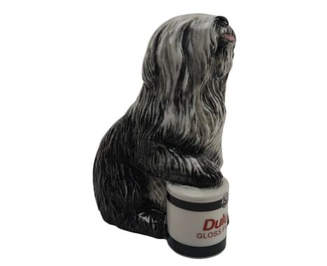 A Royal Doulton 'Celebration of 50years of Dulux' ceramic advertising figure. The Dulux dog is modelled with front paw restin